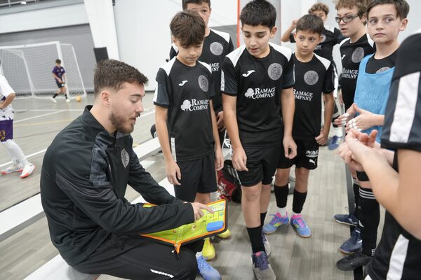 Coach Dino Hodzic talking with players on the bench