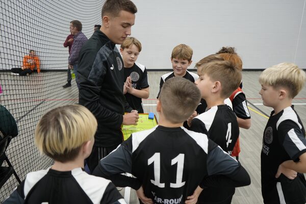 Coach Nisko Beganovic in a huddle with young players