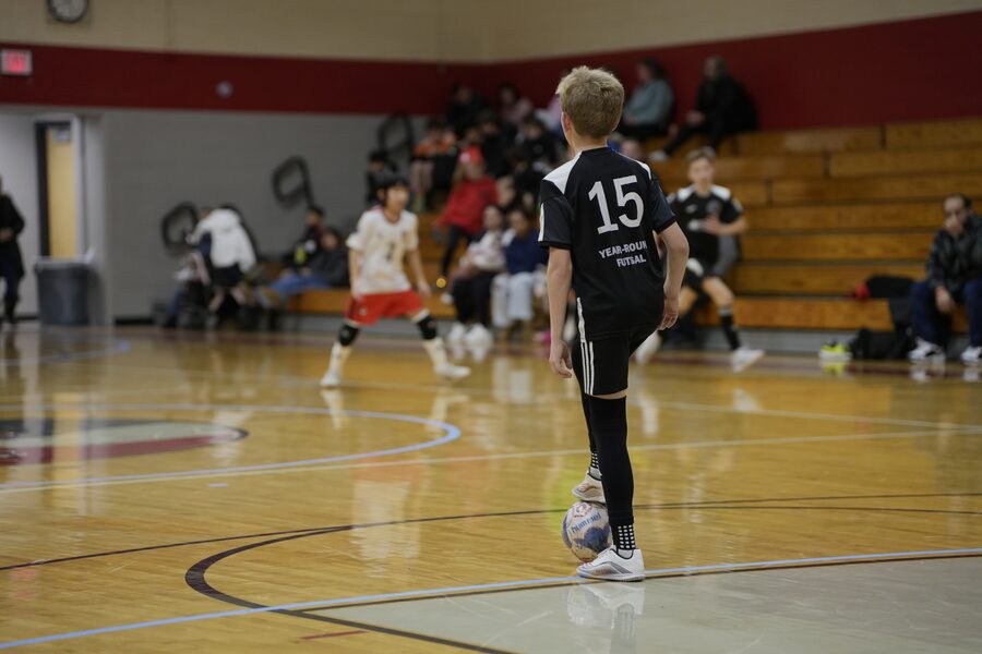 FDA player in black number 15 kit on the ball during a match